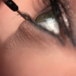 persons eye with black hair tie
