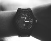 grayscale photography of person wearing black analog watch