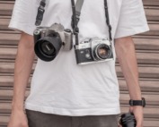 a man holding a camera and a camera strap